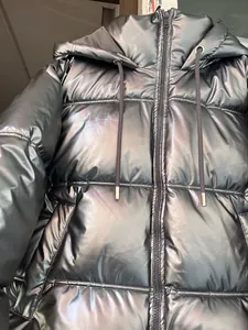 Detailed close-up of metallic shiny hooded puffer jacket for women in silver grey color