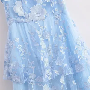 Detail view of light blue mesh summer dress featuring white 3D floral embroidery.