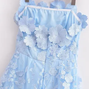 Close-up detail of light blue summer dress with exquisite 3D floral appliques.