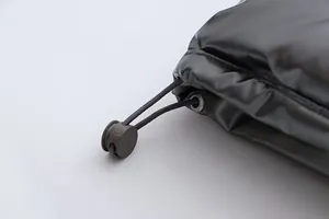 Close-up detail of the metallic glossy fabric and adjustable drawstring toggle on jacket