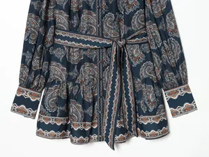 Dettaglio dell'abito blu navy con stampa paisley con cintura e orlo a volant