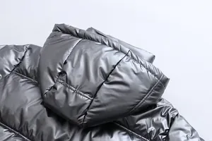 Detail view of the metallic silver hooded puffer jacket's fabric and hood design