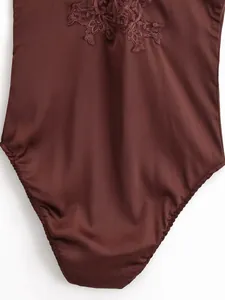 Close-up of elegant coffee satin bodysuit with delicate floral lace embroidery detail