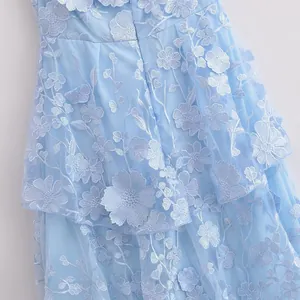 Close-up detail of light blue tiered lace dress featuring delicate 3D floral embroidery.