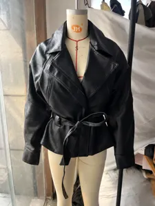 Professional detail view of a black faux leather belted jacket on a display mannequin