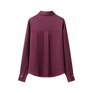 Back view of a burgundy satin shirt with box pleat detail and gold cuff buttons