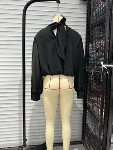 Detailed back view of a black long-sleeved blouse with a chic tie-neck bow design