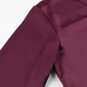 Detailed close-up of the high-quality smooth burgundy silk satin fabric on shirt shoulder