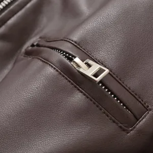 Macro detail showing a silver zipper on a brown vintage faux leather moto jacket