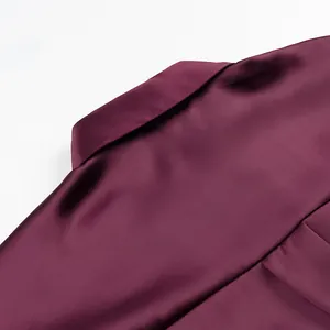 Macro detail of a luxurious burgundy satin shirt showing the elegant lapel collar texture