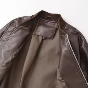 Close-up of brown faux leather bomber jacket showing interior lining and size S tag.