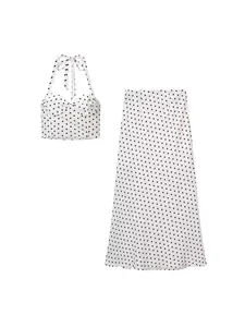 Stylish white and black polka dot two-piece set featuring a halter crop top and long skirt