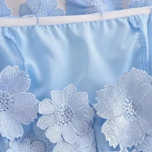 Macro view of light blue dress featuring exquisite 3D floral embroidery and satin-like fabric