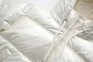 Close-up of metallic shiny white hooded puffer jacket with zipper and drawstrings