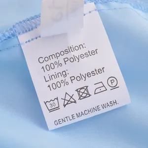 Detail showing the 100% polyester composition wash care label on a blue summer dress