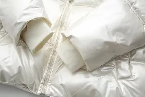 Detailed view of white metallic finish puffer jacket with windproof ribbed sleeve cuffs