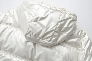 Detailed view of white metallic glossy hooded puffer jacket with quilted texture