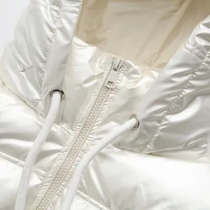 Close-up detail of glossy white puffer jacket with metallic finish and hooded zipper