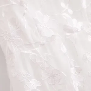 Close-up detail of high-quality white floral embroidery on breathable mesh fabric texture.