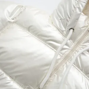 Macro detail of high-shine white metallic hooded puffer jacket with zipper and drawstring