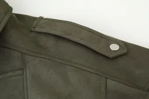 Close-up detail van de schouderepaulet op een vintage olijfgroene suède damesjas