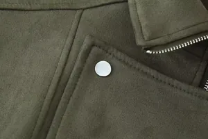 Detailopname van de olijfgroene suède stof van het jack en zilveren drukknoop