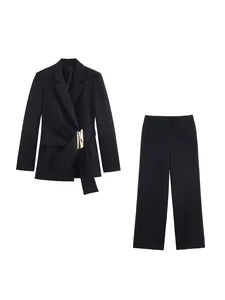 Elegante completo nero da donna con blazer con fibbia metallica e pantaloni a vita alta.