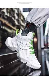 Seitenansicht der weißen klobigen Dad-Sneaker mit neongrünen Schnürsenkeln