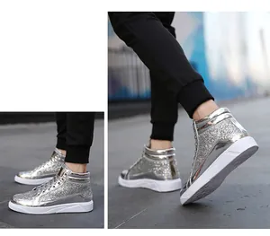 Sneaker alte con paillettes argento, inserti metallici e suola bianca in primo piano.