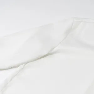 Detail shot of white satin shirt showing smooth texture and professional stitching.