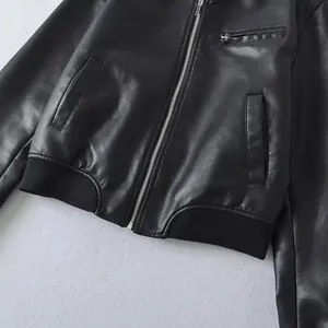 Close-up detail of metallic zipper and ribbed hem on vintage black faux leather bomber jacket