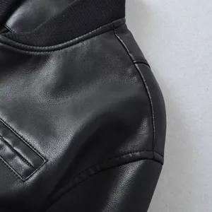 Macro detail showing textured black faux leather and stitching on women's motorcycle jacket