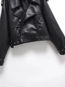 Detailed view of women's black faux leather motorcycle jacket focusing on texture and buckles