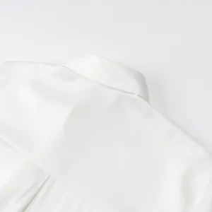 Close-up of a white satin blouse collar and yoke showing smooth fabric texture.