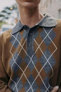 Vue détaillée d'un polo en maille pour femme avec motifs à losanges marron et gris