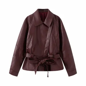 Close-up detail of a burgundy faux leather jacket featuring a stylish tied waist belt