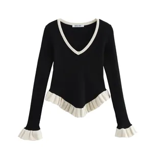 Close-up view of a V-neck long-sleeve black knit top with elegant white ruffle trim