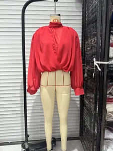Detail view of a vibrant red long-sleeved blouse with a high stand collar on a mannequin.