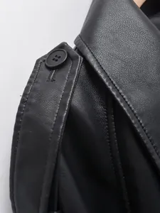 Detail view of the black faux leather moto jacket shoulder epaulet and button texture