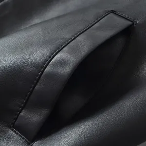 Macro close-up of pocket stitching detail on a black faux leather biker jacket.