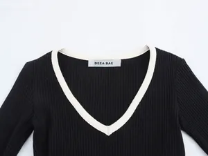 Detail of V-neck long-sleeved knit top with contrast trim and ribbed texture