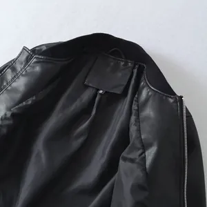 Close-up macro detail of black faux leather bomber jacket interior lining and size tag