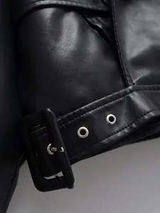 Close-up macro detail of the belt buckle and eyelets on a black faux leather biker jacket