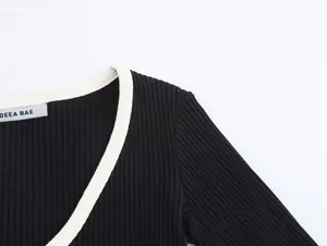 Close-up of V-neck long sleeve knit top with white contrast ribbed collar