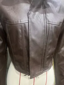 Detailweergave van donkerbruin kunstleren jasje met trendy stiksels in korsetstijl