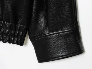 Detailansicht der Manschette und Saumnähte einer schwarzen Kunstlederjacke
