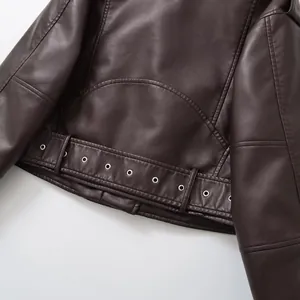 Gros plan d'une veste de motard vintage en similicuir marron avec ceinture à œillets.