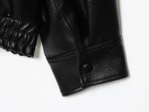 Nahaufnahme einer schwarzen Kunstlederjacke mit litchiartiger Narbung und Manschette