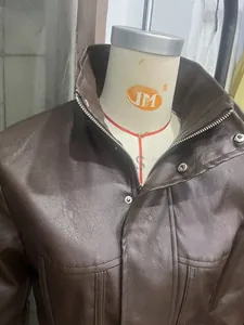 Detailweergave van de opstaande kraag en PU-leertextuur van deze bruine damesjas