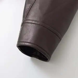 Gros plan du poignet d'une veste en similicuir marron avec grain fin et coutures